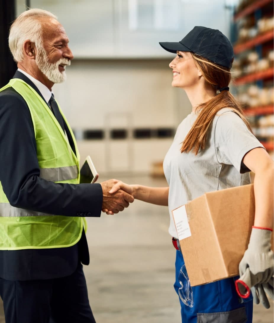 Poignée de main dans un entrepôt. Client ISB France et employée avec un colis.