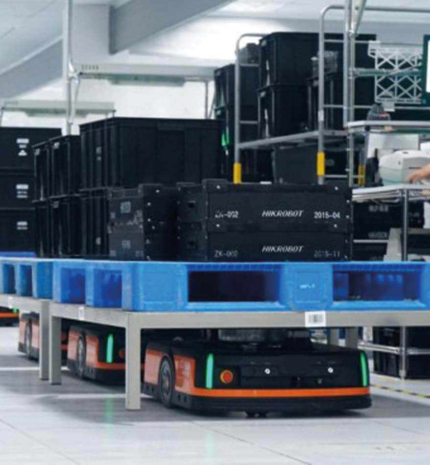 Robot mobile HIKRobot transportant des bacs dans un entrepôt automatisé. Logistique et manutention.