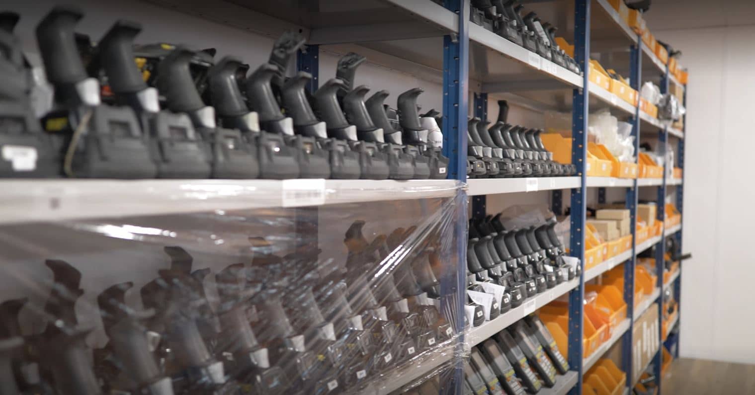 Étagères remplies d'équipement noir et de bacs orange, illustrant les services WIIO.