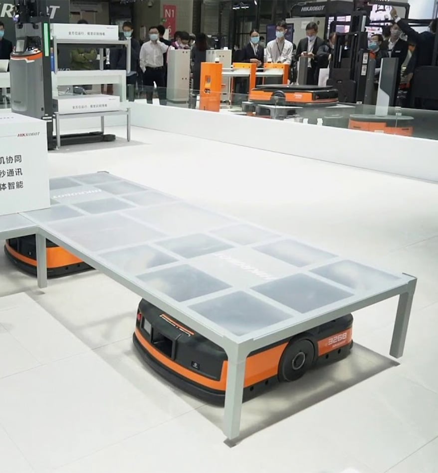 Robot mobile LMR HIKRobot orange transportant une plateforme blanche dans un entrepôt.