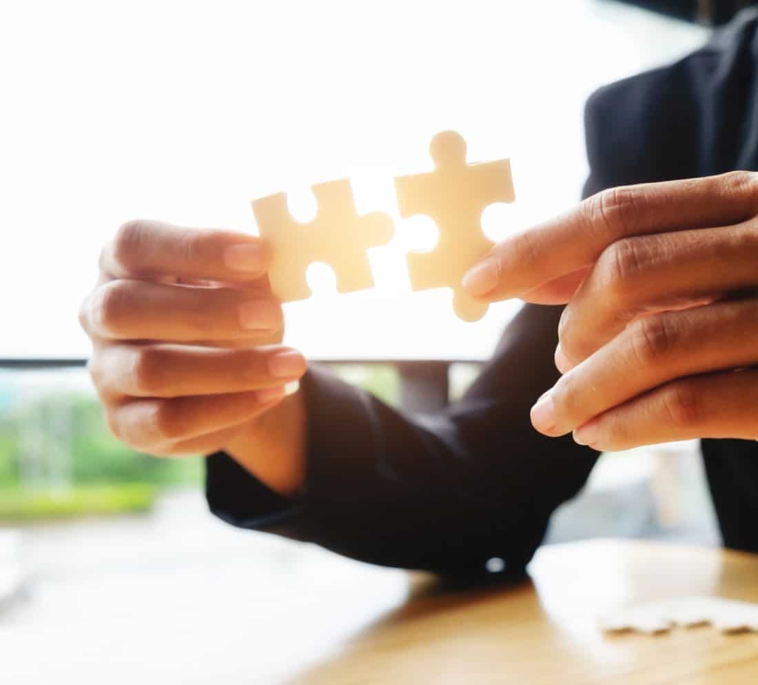 Personne tenant deux pièces de puzzle, concept de formations certifiées.