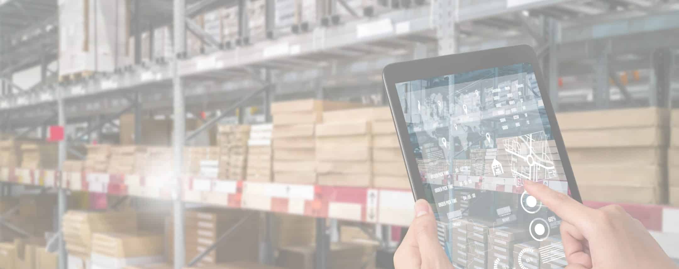 Person using a tablet to manage inventory in a warehouse with shelves of boxes and products in the background.