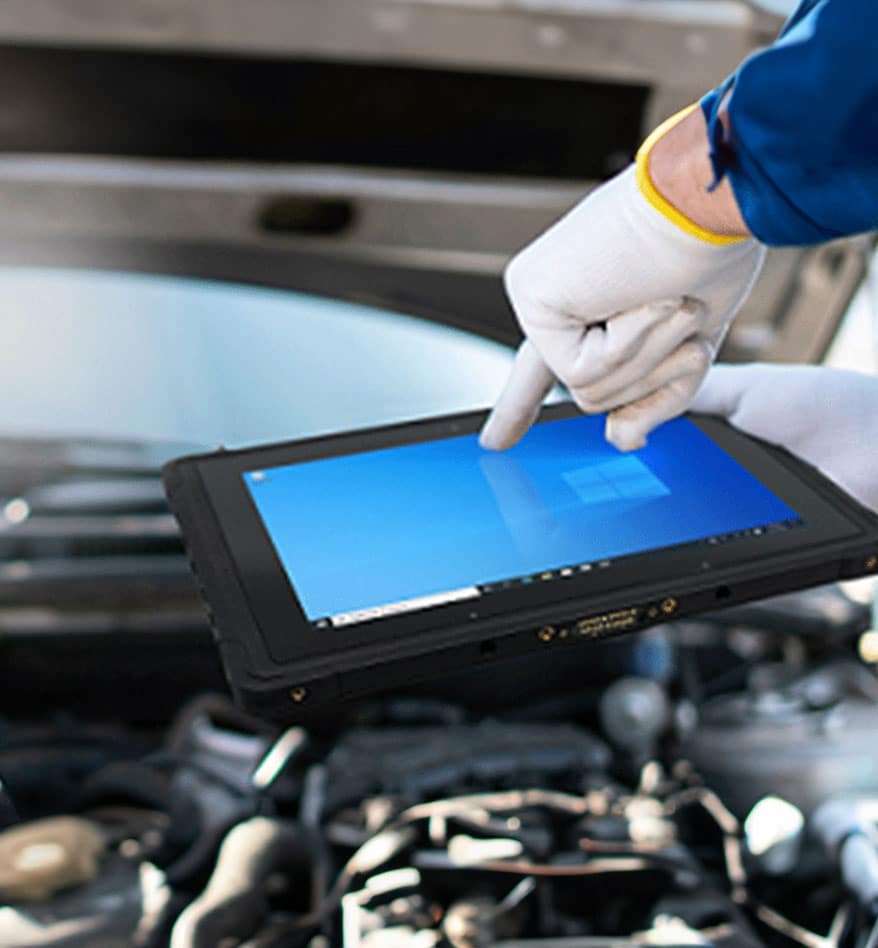 Mécanicien utilisant une Tablette Unitech TB170 pour diagnostiquer un moteur de voiture.