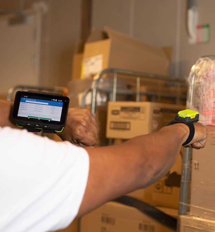 Employé utilisant un terminal mains-libres Zebra WT5400 dans un entrepôt.