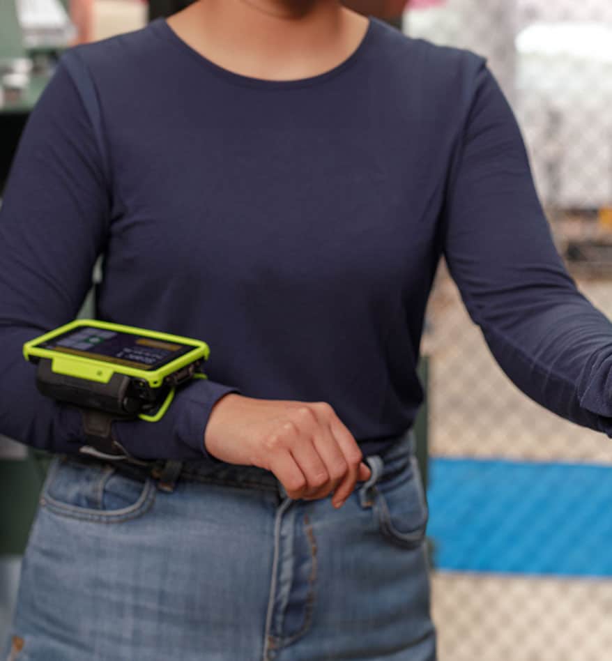 Employée utilisant un terminal mains-libres Zebra WT6400 sur son bras.