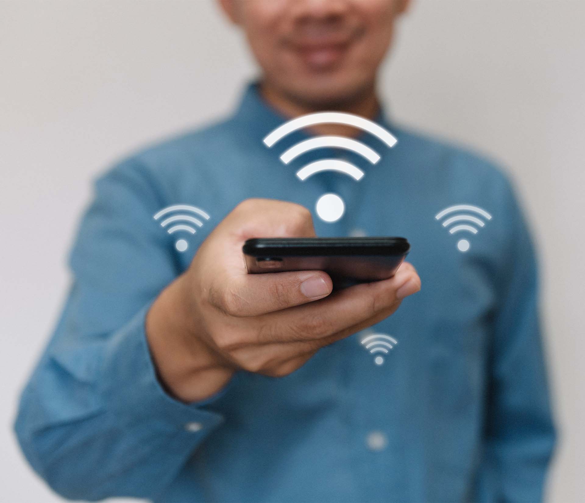 Homme utilisant un smartphone avec icônes Wi-Fi. Glossaire K-Z.