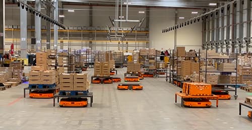Robots transportant des palettes dans un grand entrepôt, solution "pallet to person".