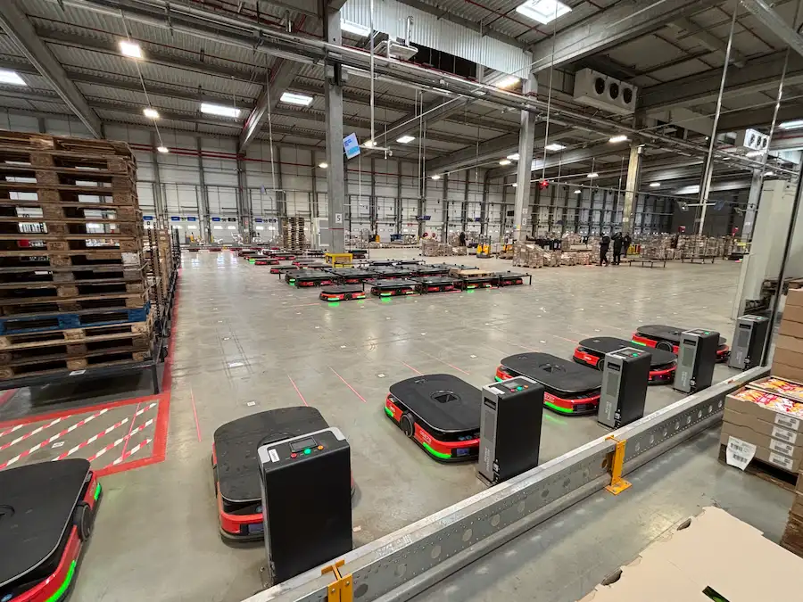 Robots "pallet to person" travaillant dans un grand entrepôt moderne. Flux tendus.