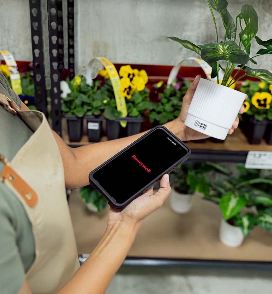 terminal mobile honeywell ct70 photo d'une personne qui scanne un pot de fleur